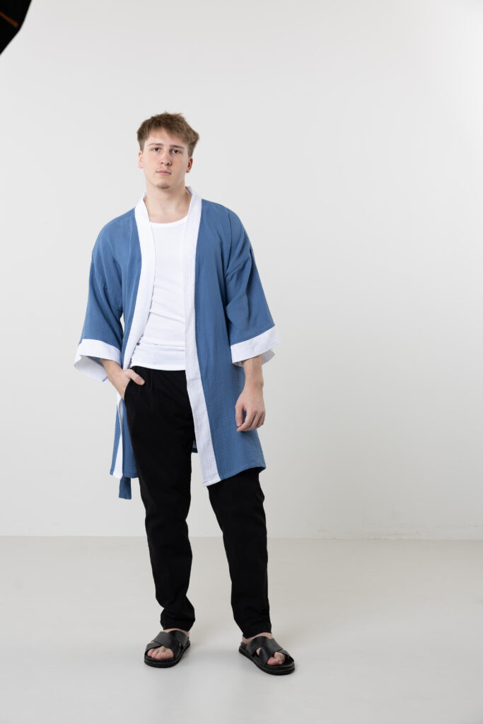 Artisanal abstract face embroidered muslin wrap kimono; unisex line-art cotton duster for sustainable resort wear, travel, and modern bohemian style.