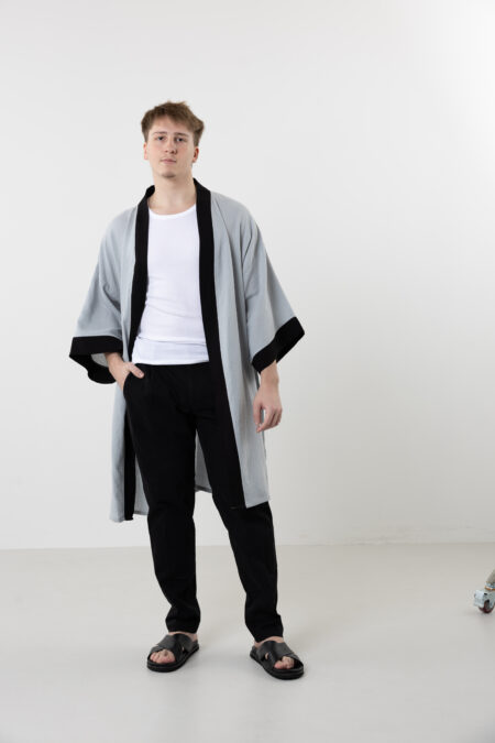 Artisanal abstract face embroidered muslin wrap kimono; unisex line-art cotton duster for sustainable resort wear, travel, and modern bohemian style.