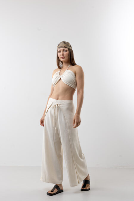 Artisanal natural cotton double-tie wrap pants; adjustable cream open-side trousers with front and back ties for sustainable resort wear and minimalist travel style.
