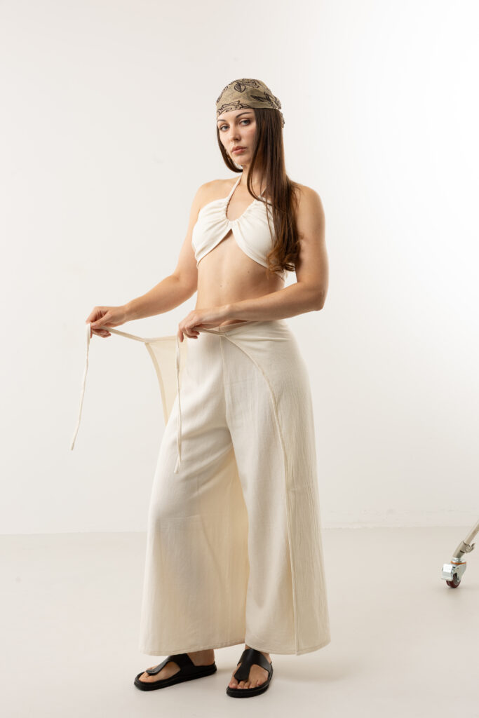 Artisanal natural cotton double-tie wrap pants; adjustable cream open-side trousers with front and back ties for sustainable resort wear and minimalist travel style.