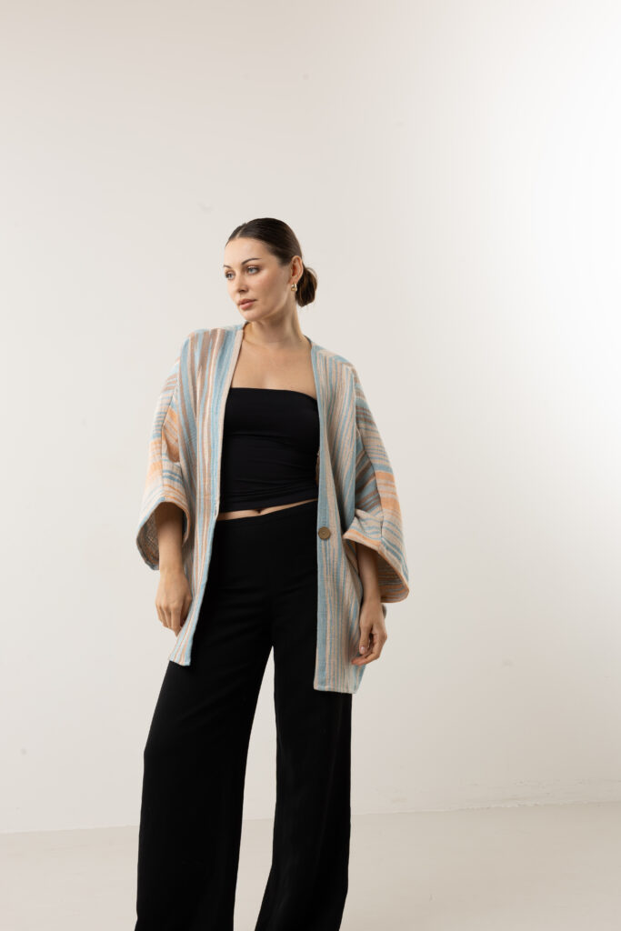 Detailed view of the 25 cm relaxed armhole and 55 cm sleeve on a textured cotton cardigan.