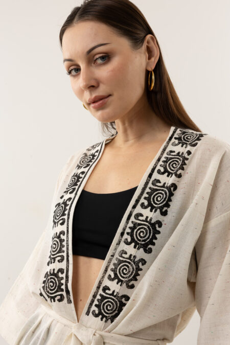 Close-up of black woodblock symbols on speckled grey-cream linen fabric.