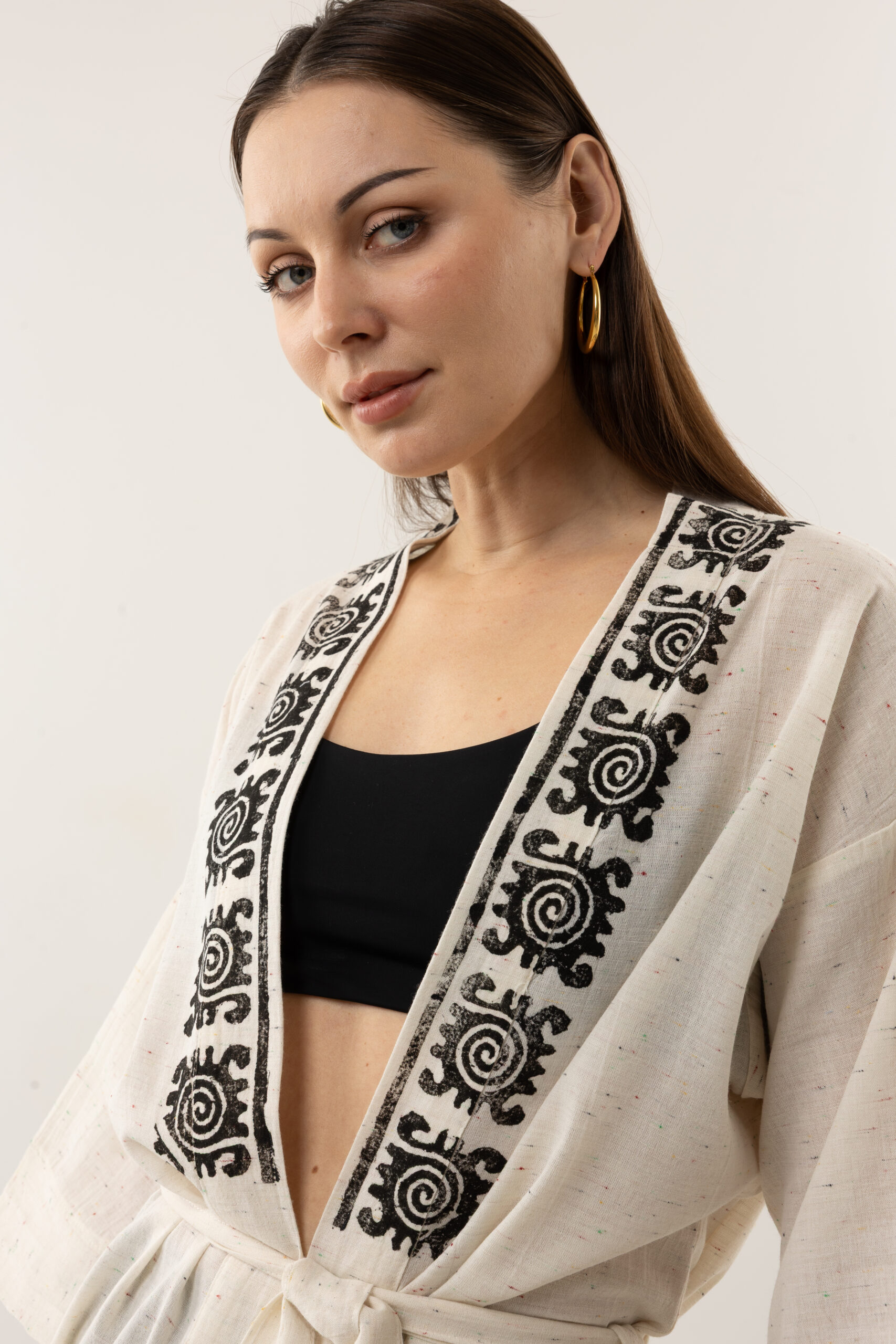 Close-up of black woodblock symbols on speckled grey-cream linen fabric.