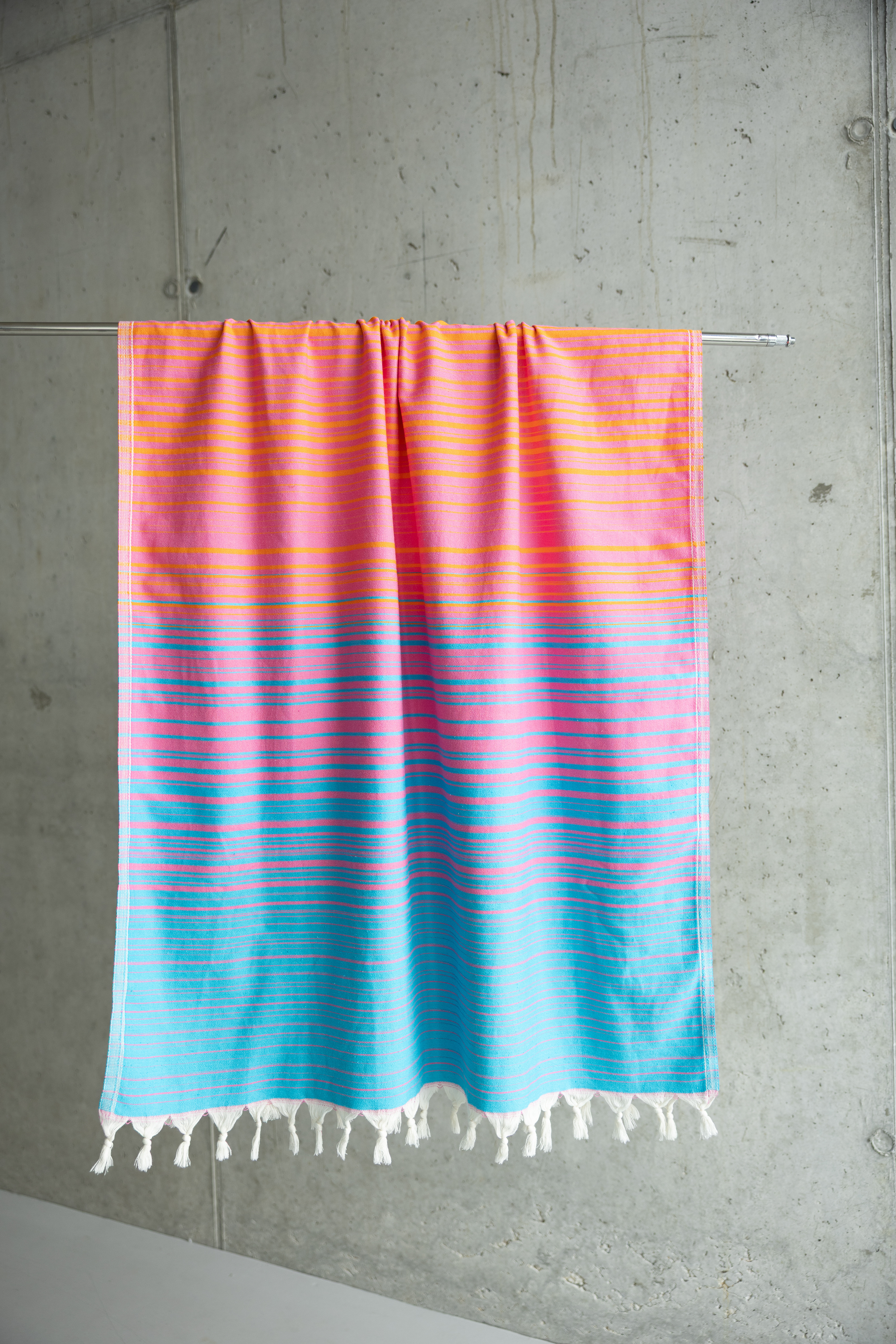 Close-up of hand-tied tassels on a rainbow striped cotton peshtemal