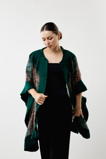 Flowing silhouette of a handcrafted green silk poncho - Artistic wearable wrap