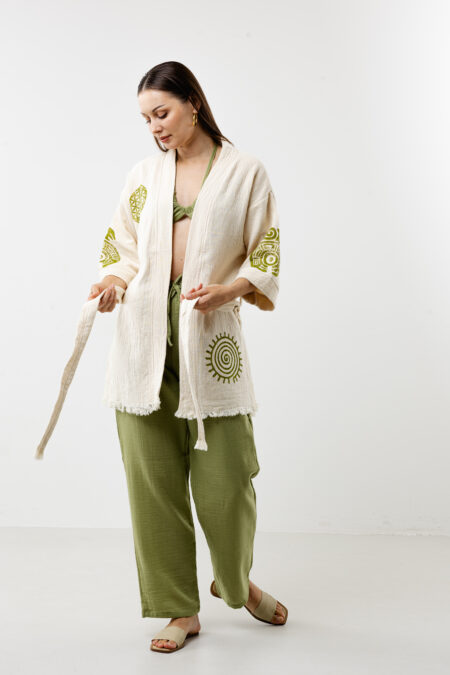 Short artisanal cotton kimono in natural cream with green woodblock spiral patterns.