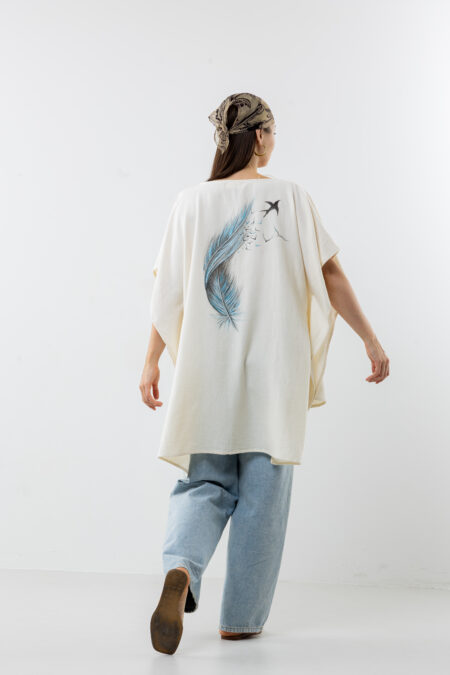 Hand-painted feather design vest; artisanal bohemian layering piece for sustainable resort wear and travel.
