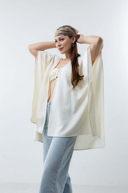 Hand-painted feather design vest; artisanal bohemian layering piece for sustainable resort wear and travel.