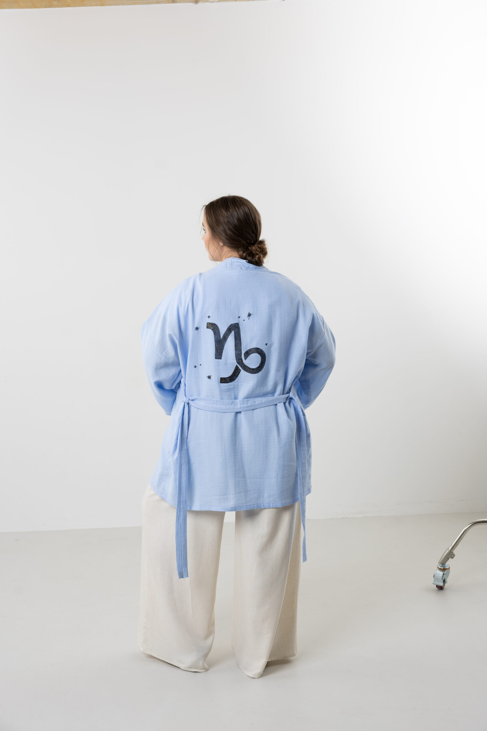 Hand-painted zodiac mini muslin kimono; multi-color naturally dyed jacket with black celestial symbols for sustainable resort wear and travel.