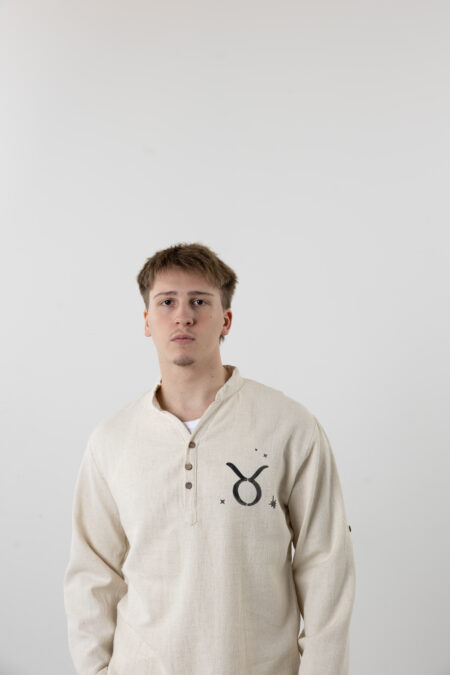 Close-up of hand-painted Taurus constellation and zodiac symbols on a linen shirt.