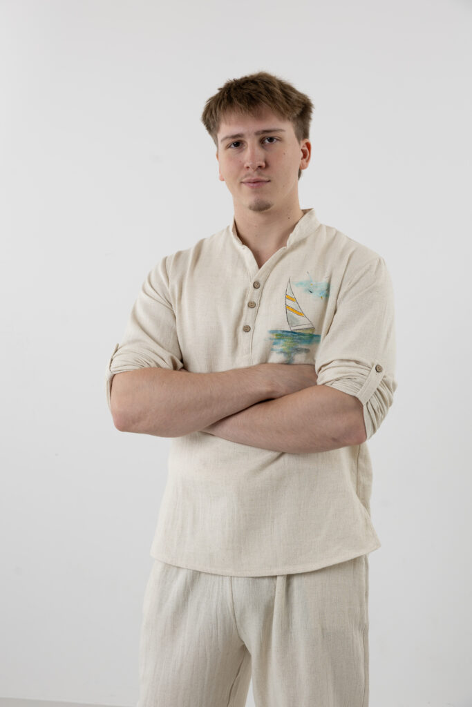 Side view of men's cream Henley shirt with nautical sail boat detail.