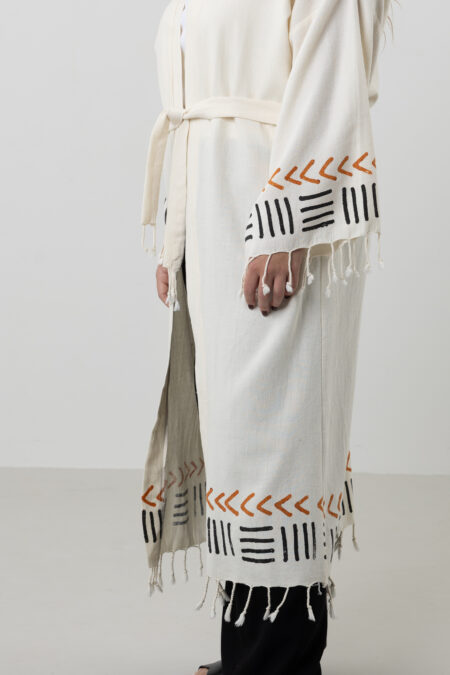 Close-up of kimono sleeve cuff with block print and tassel details.