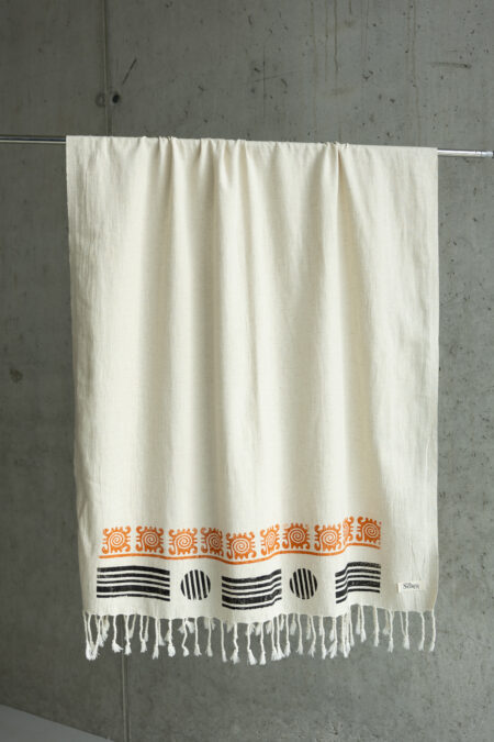 Close-up of brown handcrafted wood block print on natural cream fabric