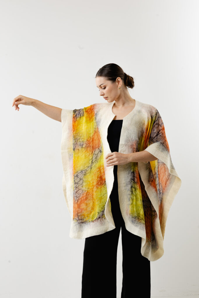 Intricate hand-painted golden and amber patterns on bright silk fabric