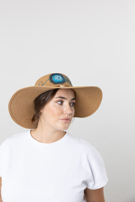Close-up of hand-painted luck symbols and charms on a women's straw hat.