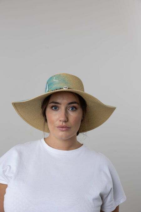 Close-up of hand-painted sailing boat and sea waves on a women's straw hat.