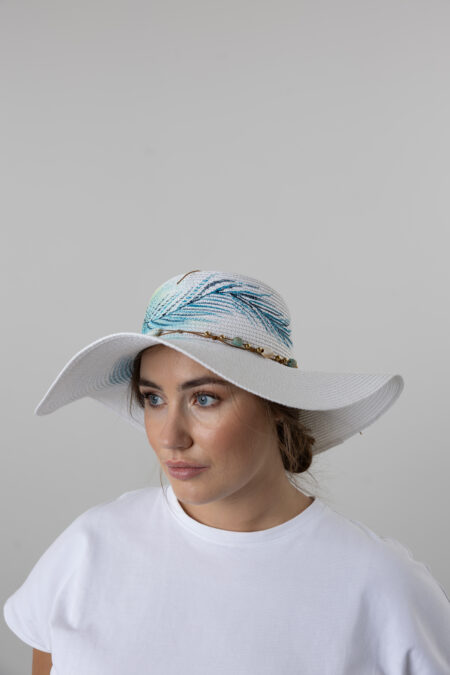Close-up of hand-painted Evil Eye artwork on a women's straw hat.